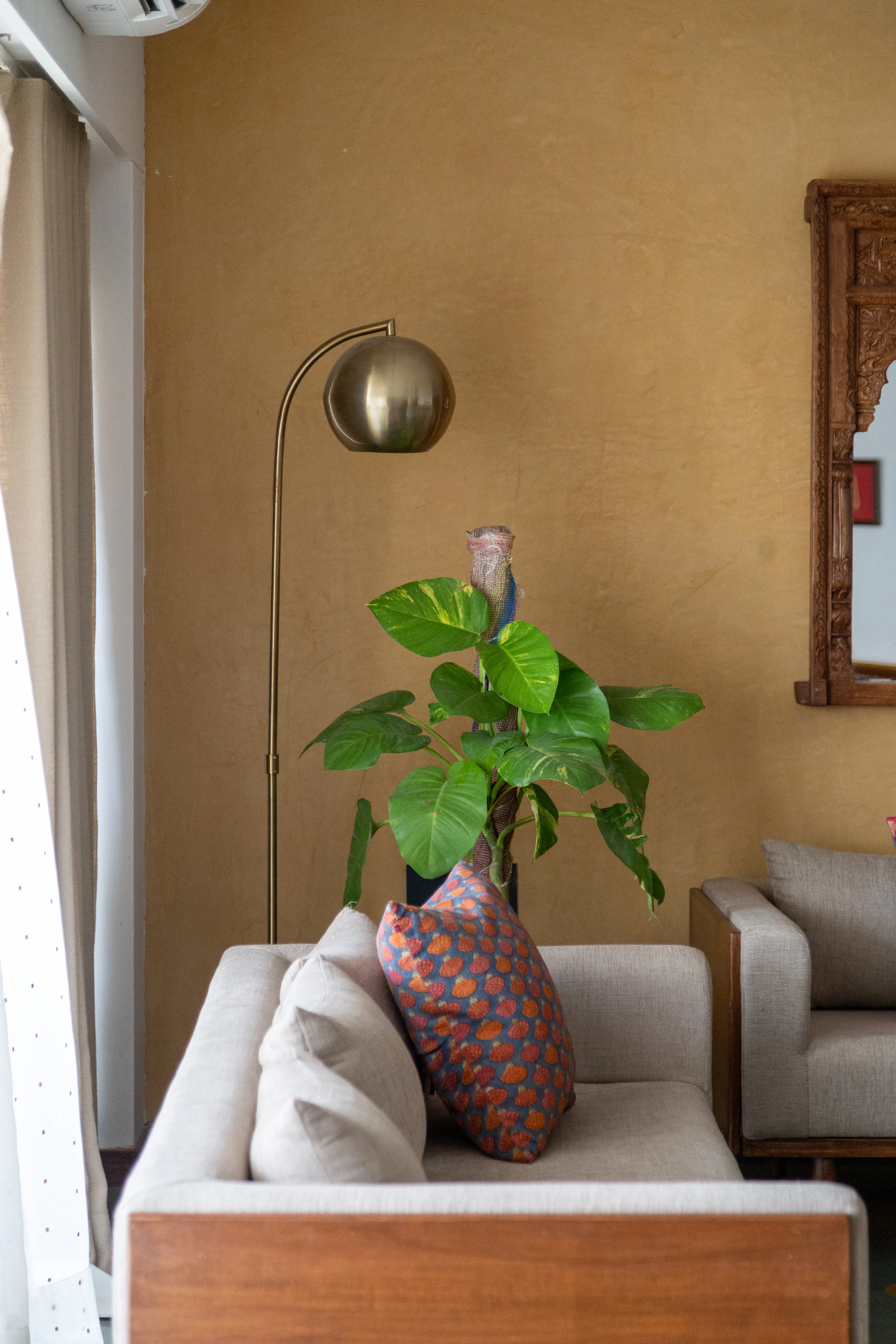 Alankāra living corner with warm brass lamp and artisanal textures