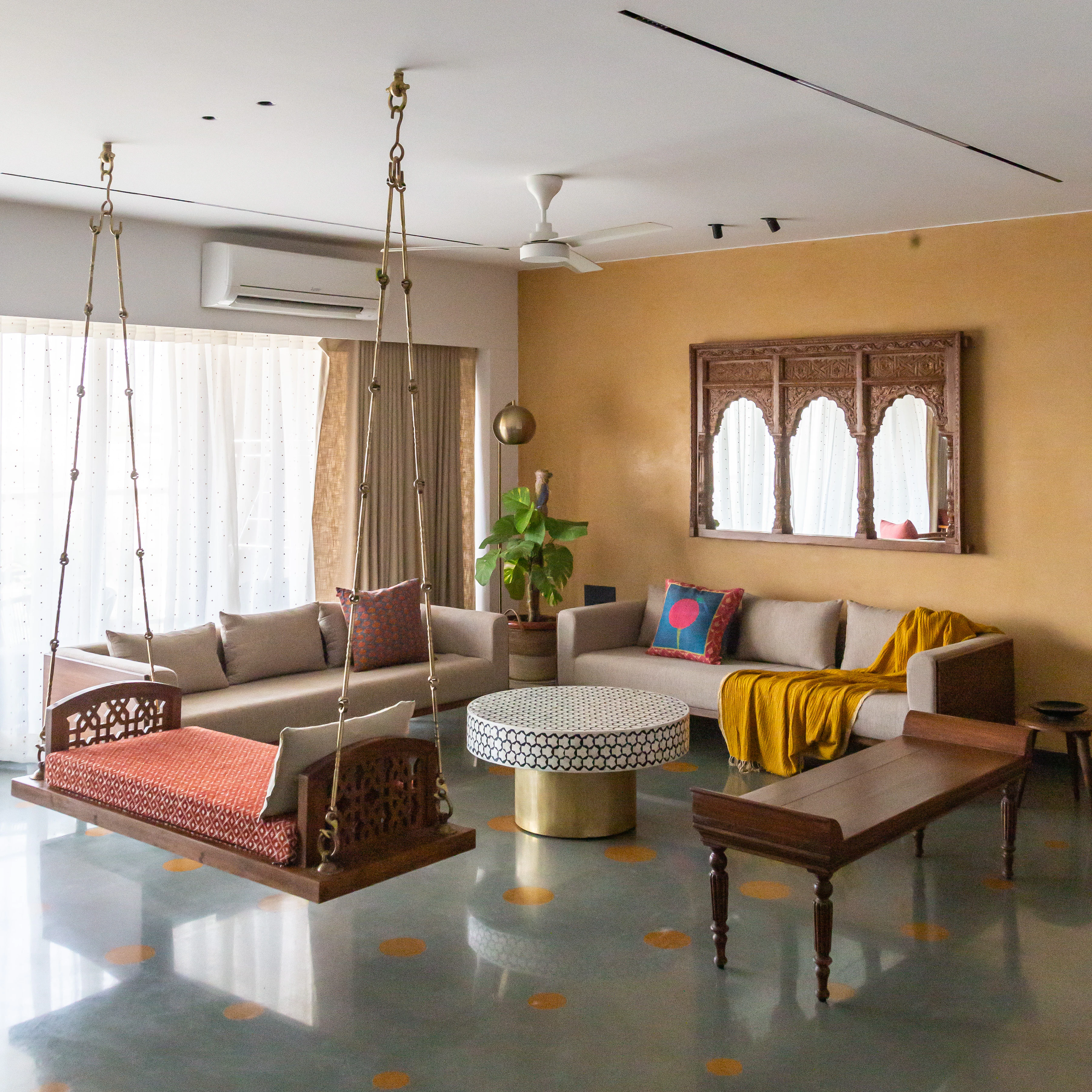 Alankāra living room with traditional carved wooden swing and brass detailing