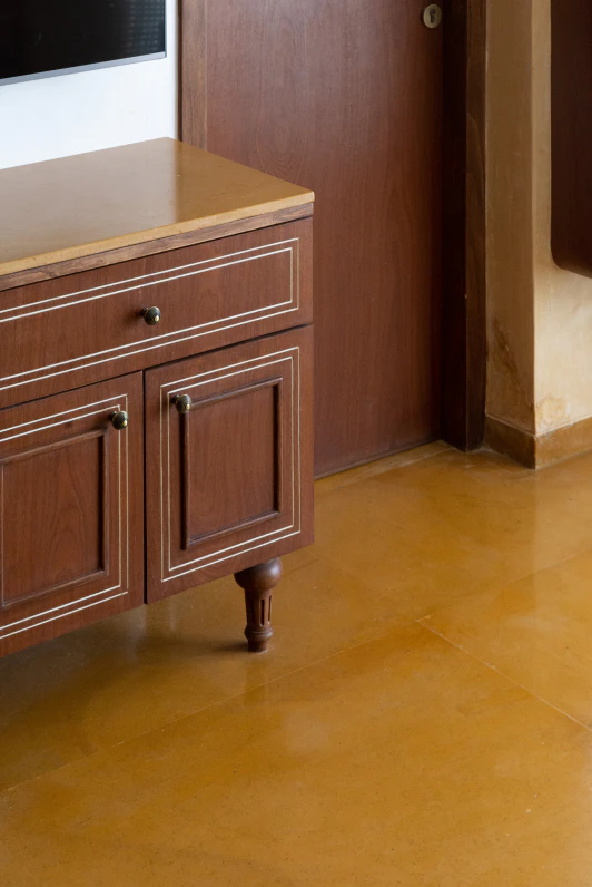 Handcrafted wooden console with fine inlay trim on warm stone flooring