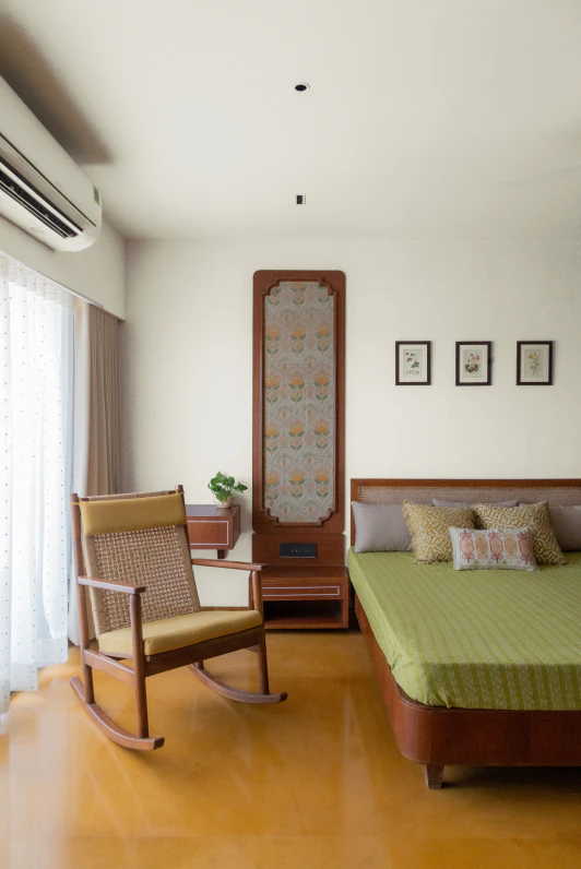 Bedroom suite featuring woven cane rocking chair and ornamental fabric wall panel