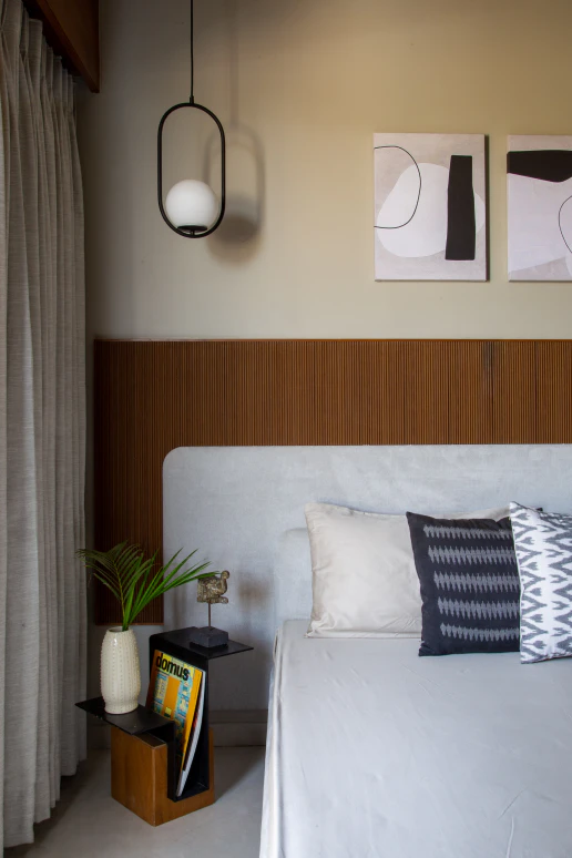 Minimalist bedroom with tall upholstered headboard and warm ambient sconce