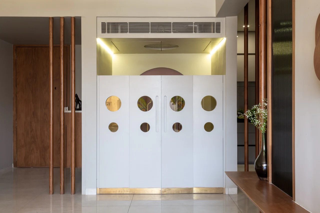 House 709 mandir with white doors, geometric brass apertures, and brass skirting