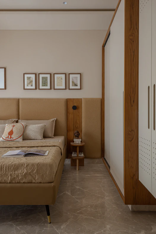 Bedroom with tan upholstered panel headboard, timber panel with reading light, and perforated wardrobe detail