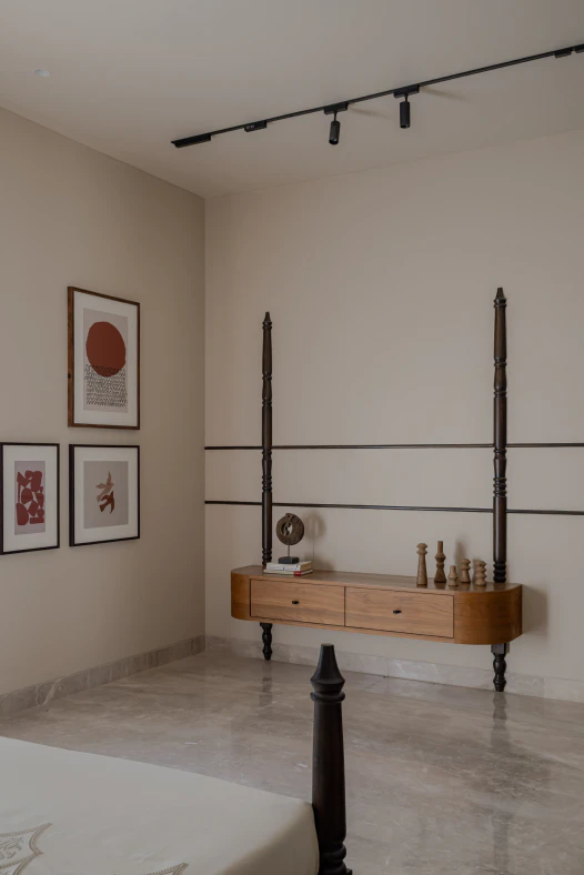 Floating curved wooden console table flanked by turned dark wood posts with artisanal wooden decor accents