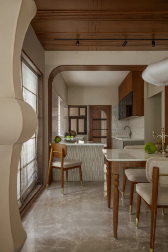 Perspective through the timber archway toward the dining table, breakfast counter, and slatted wood ceiling