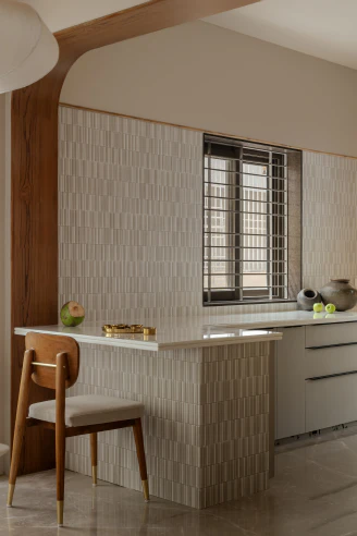 Kitchen breakfast counter featuring a fluted tile base, white stone countertop, and arched timber surround