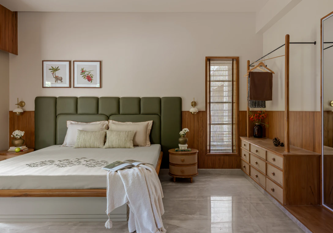 Master bedroom suite with olive-green tufted headboard, warm timber wall paneling, and open wardrobe rail